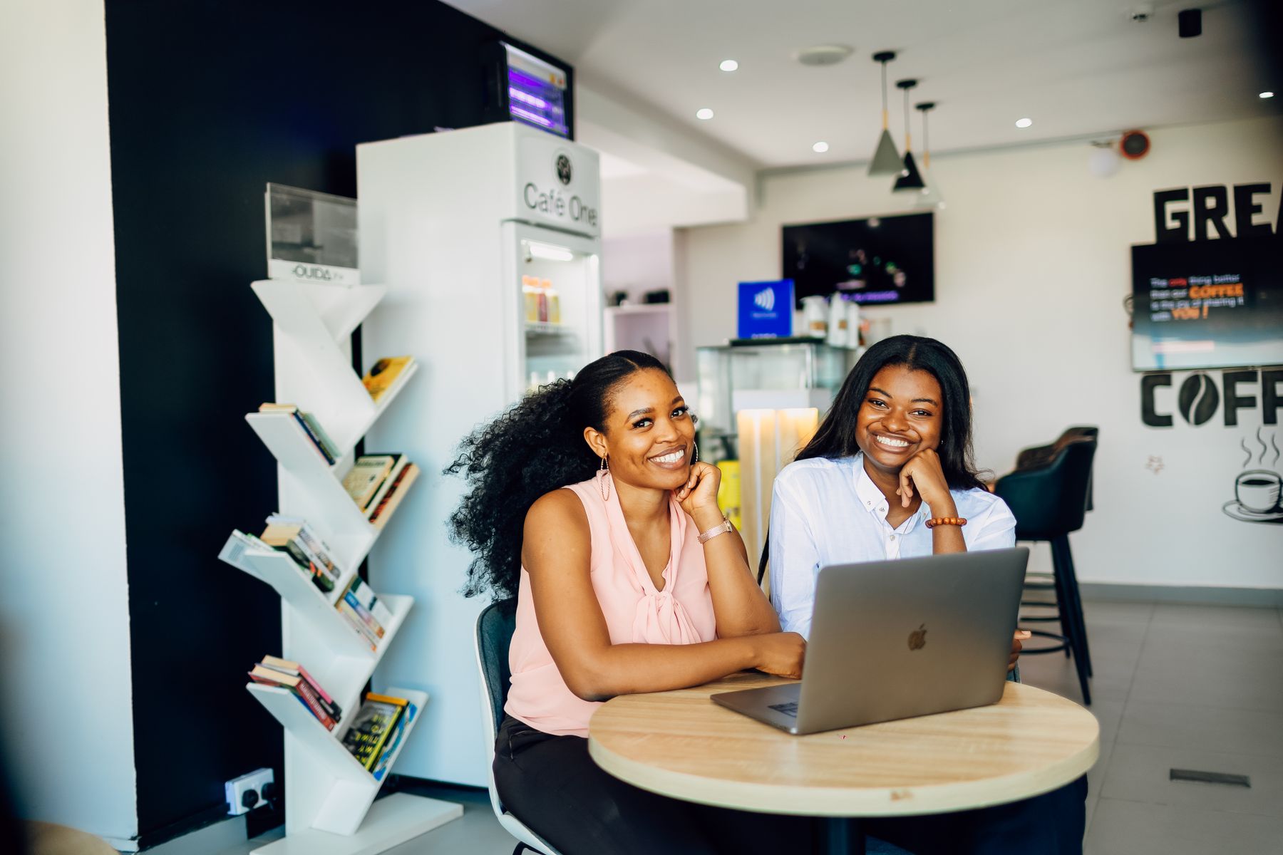 Nigerian businesswomen reviewing work together with a laptop in a Lagos café